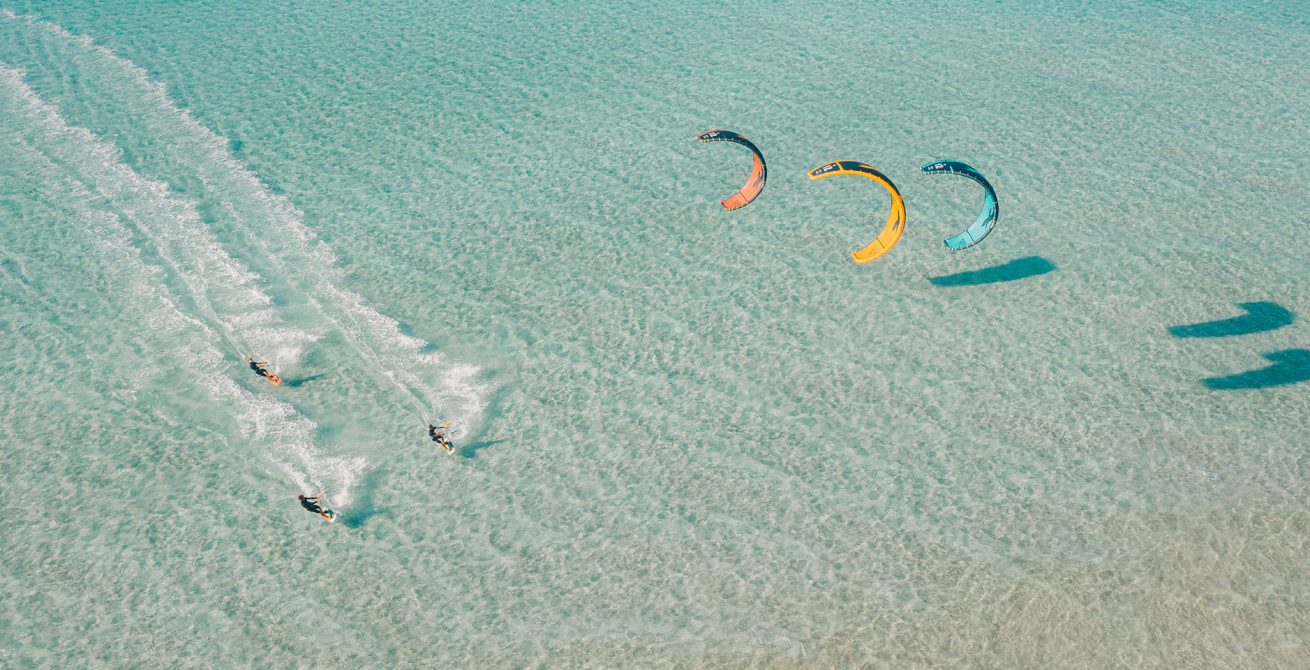 F-One Bandit 2021 Kite - Dynamic Action Shot - Blue Sky and Waves